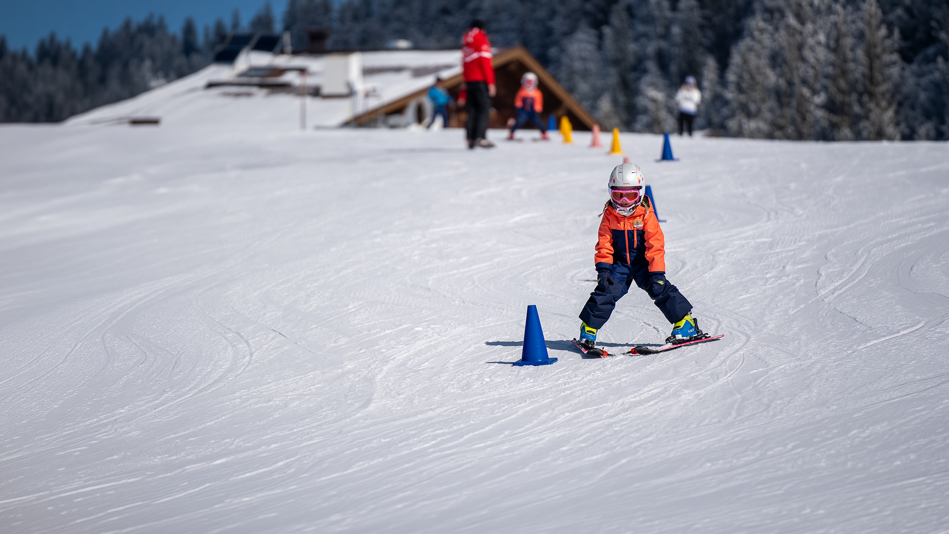 Kind fährt im Schneepflug über die Piste und zeigt beim Skikurs in Westendorf, was es für das Abschlussrennen gelernt hat