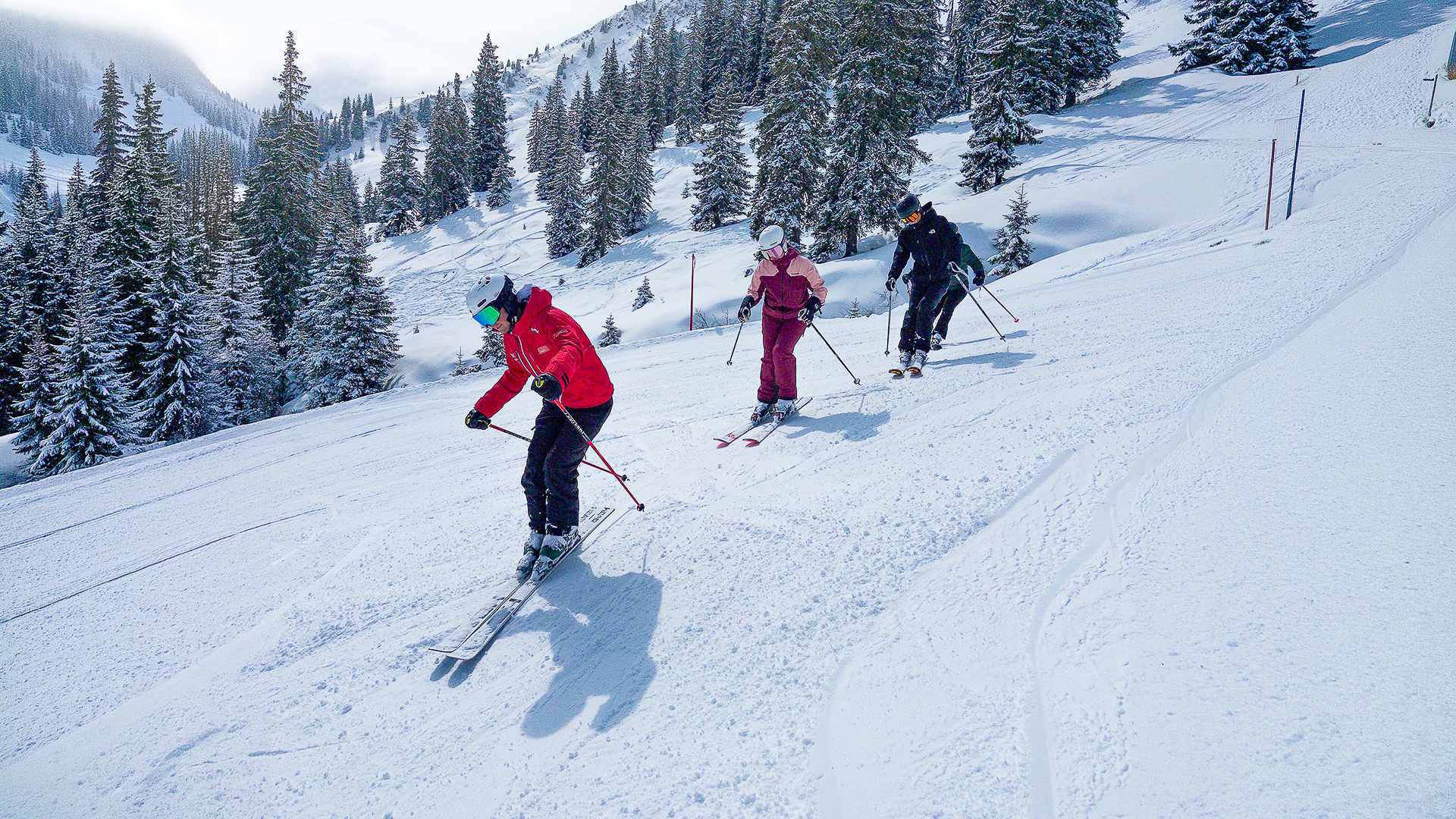 Skilehrer in verschneiter Winterlandschaft mit seinen Schülern
