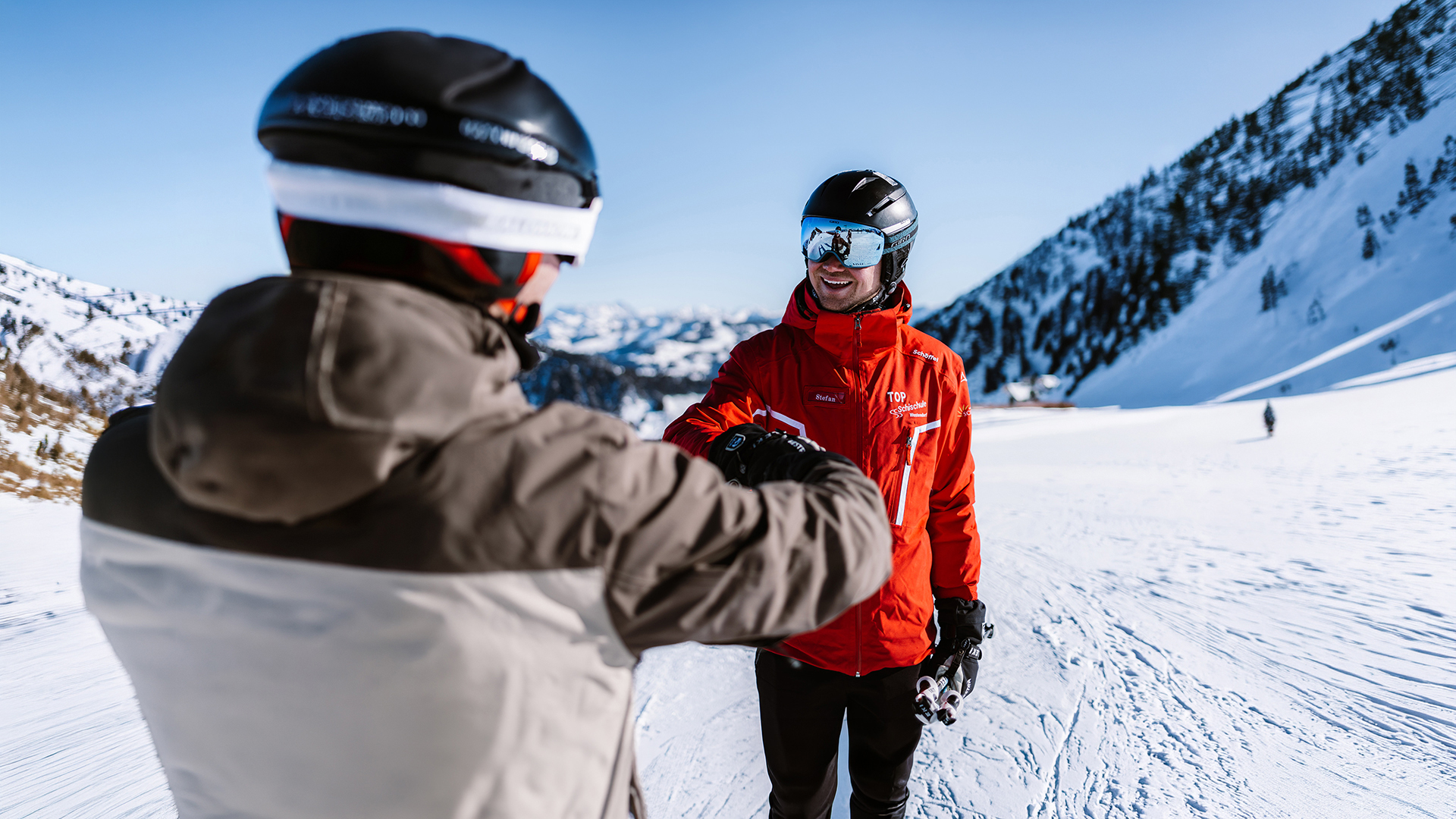Freundlicher Skilehrer der TOP Skischule Westendorf gibt einem Schüler Privatunterricht